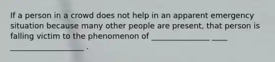 If a person in a crowd does not help in an apparent emergency situation because many other people are present, that person is falling victim to the phenomenon of _______________ ____ ___________________ .