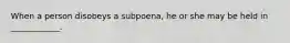 When a person disobeys a subpoena, he or she may be held in ____________.