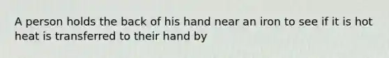 A person holds the back of his hand near an iron to see if it is hot heat is transferred to their hand by