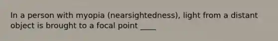 In a person with myopia (nearsightedness), light from a distant object is brought to a focal point ____