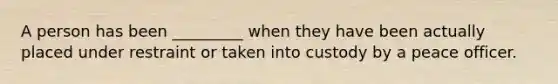 A person has been _________ when they have been actually placed under restraint or taken into custody by a peace officer.