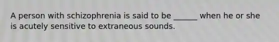 A person with schizophrenia is said to be ______ when he or she is acutely sensitive to extraneous sounds.