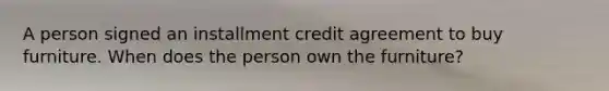 A person signed an installment credit agreement to buy furniture. When does the person own the furniture?