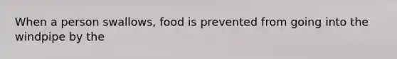 When a person swallows, food is prevented from going into the windpipe by the