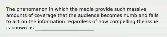 The phenomenon in which the media provide such massive amounts of coverage that the audience becomes numb and fails to act on the information regardless of how compelling the issue is known as _________________________.