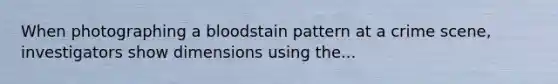 When photographing a bloodstain pattern at a crime scene, investigators show dimensions using the...