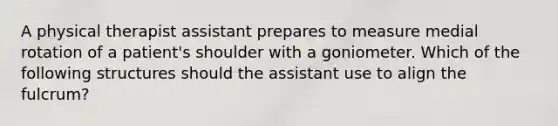 A physical therapist assistant prepares to measure medial rotation of a patient's shoulder with a goniometer. Which of the following structures should the assistant use to align the fulcrum?