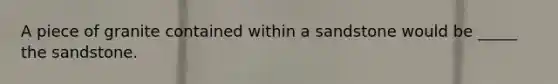 A piece of granite contained within a sandstone would be _____ the sandstone.