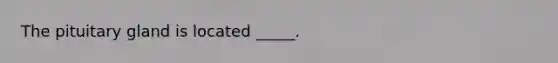 The pituitary gland is located _____.