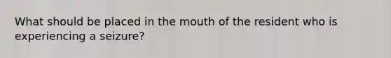 What should be placed in the mouth of the resident who is experiencing a seizure?