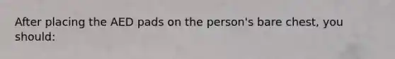 After placing the AED pads on the person's bare chest, you should: