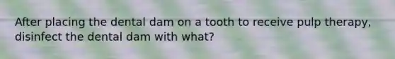 After placing the dental dam on a tooth to receive pulp therapy, disinfect the dental dam with what?