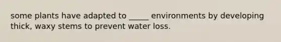 some plants have adapted to _____ environments by developing thick, waxy stems to prevent water loss.