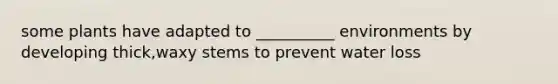some plants have adapted to __________ environments by developing thick,waxy stems to prevent water loss