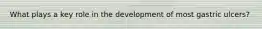 What plays a key role in the development of most gastric ulcers?
