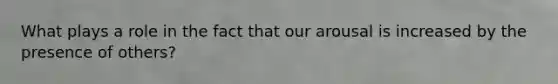 What plays a role in the fact that our arousal is increased by the presence of others?
