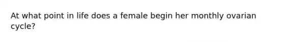 At what point in life does a female begin her monthly ovarian cycle?