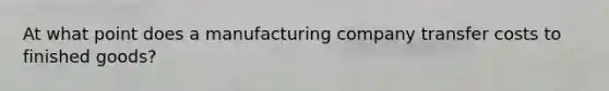 At what point does a manufacturing company transfer costs to finished goods?