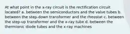 At what point in the x-ray circuit is the rectification circuit located? a. between the semiconductors and the valve tubes b. between the step-down transformer and the rheostat c. between the step-up transformer and the x-ray tube d. between the thermionic diode tubes and the x-ray machines