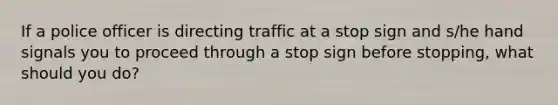 If a police officer is directing traffic at a stop sign and s/he hand signals you to proceed through a stop sign before stopping, what should you do?