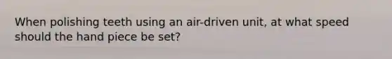 When polishing teeth using an air-driven unit, at what speed should the hand piece be set?