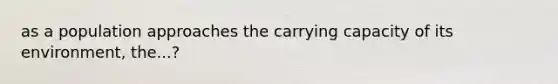 as a population approaches the carrying capacity of its environment, the...?