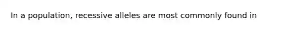 In a population, recessive alleles are most commonly found in