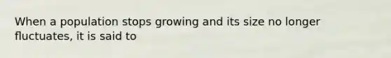 When a population stops growing and its size no longer ﬂuctuates, it is said to