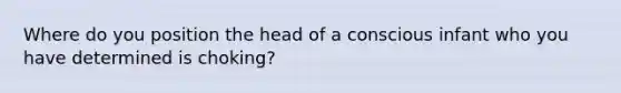 Where do you position the head of a conscious infant who you have determined is choking?