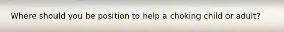 Where should you be position to help a choking child or adult?