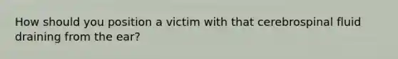 How should you position a victim with that cerebrospinal fluid draining from the ear?