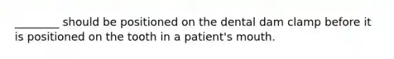 ________ should be positioned on the dental dam clamp before it is positioned on the tooth in a patient's mouth.