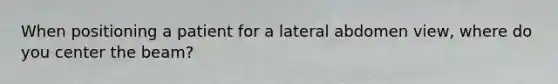 When positioning a patient for a lateral abdomen view, where do you center the beam?