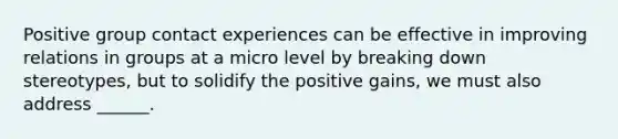 Positive group contact experiences can be effective in improving relations in groups at a micro level by breaking down stereotypes, but to solidify the positive gains, we must also address ______.