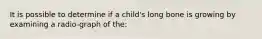 It is possible to determine if a child's long bone is growing by examining a radio-graph of the: