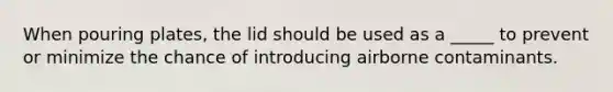 When pouring plates, the lid should be used as a _____ to prevent or minimize the chance of introducing airborne contaminants.