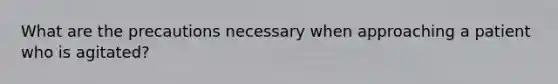 What are the precautions necessary when approaching a patient who is agitated?