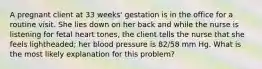 A pregnant client at 33 weeks' gestation is in the office for a routine visit. She lies down on her back and while the nurse is listening for fetal heart tones, the client tells the nurse that she feels lightheaded; her blood pressure is 82/58 mm Hg. What is the most likely explanation for this problem?