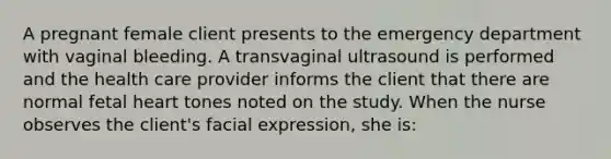 A pregnant female client presents to the emergency department with vaginal bleeding. A transvaginal ultrasound is performed and the health care provider informs the client that there are normal fetal heart tones noted on the study. When the nurse observes the client's facial expression, she is: