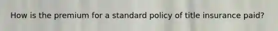 How is the premium for a standard policy of title insurance paid?