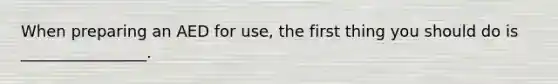 When preparing an AED for use, the first thing you should do is ________________.