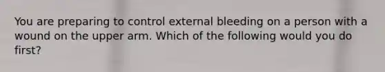 You are preparing to control external bleeding on a person with a wound on the upper arm. Which of the following would you do first?