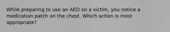 While preparing to use an AED on a victim, you notice a medication patch on the chest. Which action is most appropriate?