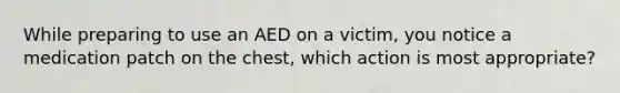 While preparing to use an AED on a victim, you notice a medication patch on the chest, which action is most appropriate?