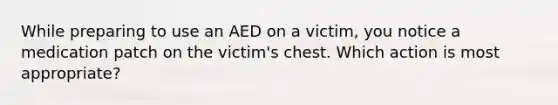 While preparing to use an AED on a victim, you notice a medication patch on the victim's chest. Which action is most appropriate?