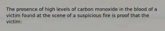 The presence of high levels of carbon monoxide in the blood of a victim found at the scene of a suspicious fire is proof that the victim: