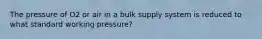 The pressure of O2 or air in a bulk supply system is reduced to what standard working pressure?