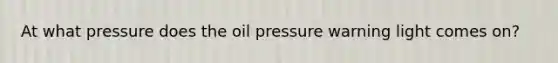 At what pressure does the oil pressure warning light comes on?