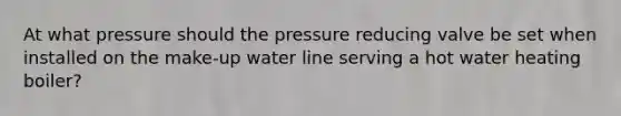 At what pressure should the pressure reducing valve be set when installed on the make-up water line serving a hot water heating boiler?