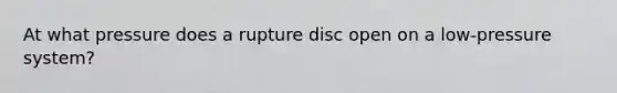 At what pressure does a rupture disc open on a low-pressure system?